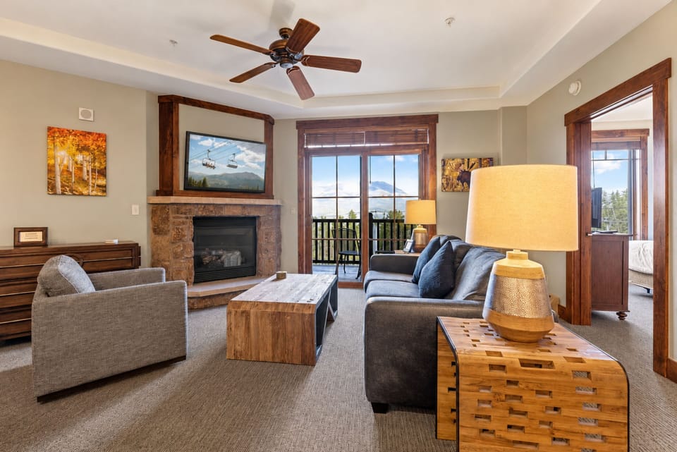 Unwind in your living space where a cozy fireplace and plush seating create the perfect retreat after a day of mountain adventures. The balcony invites you to breathe in the fresh air and soak in stunning views.