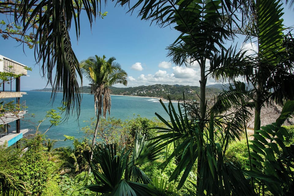 Lush tropical garden framing full Sayulita Bay and beach panorama