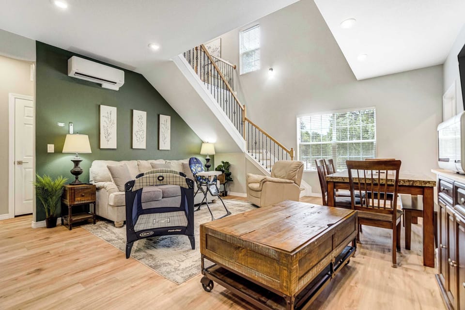 Vaulted ceilings and a deep green accent wall give the living area real height and character. Windows set on two levels pull daylight in through the day, and a mini split keeps the space cool through the warmer summer months.