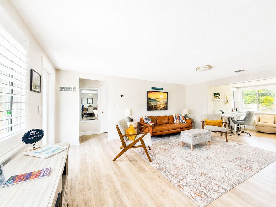 Bright, spacious living room with leather sofa and dedicated workspace