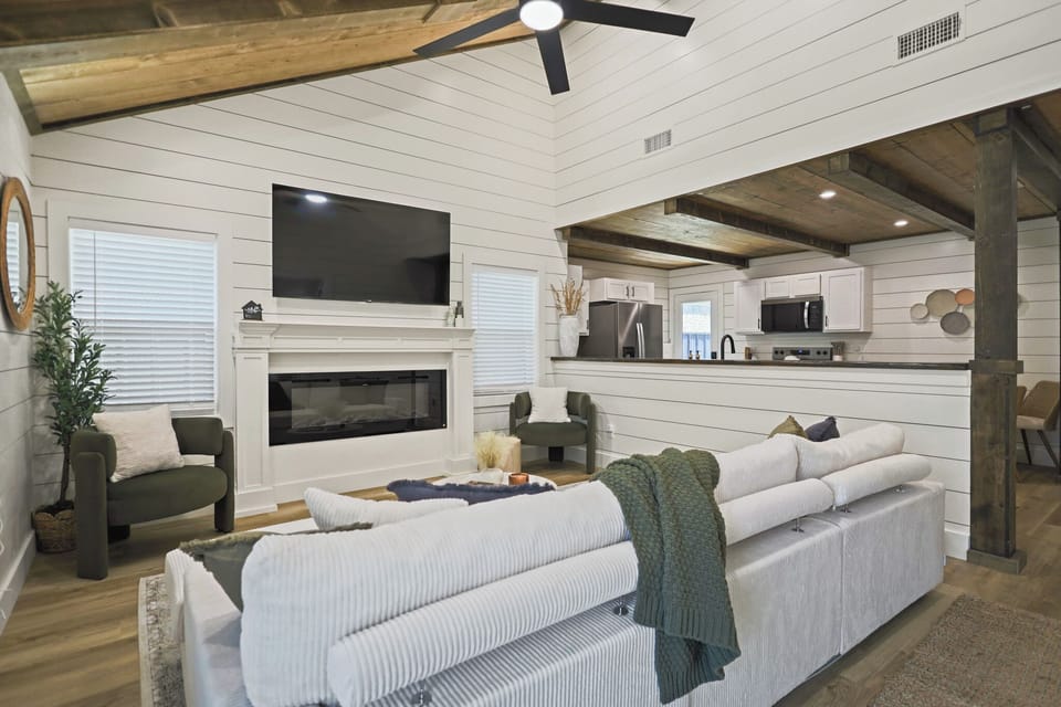 Vaulted great room with fireplace, big TV, and stylish open kitchen