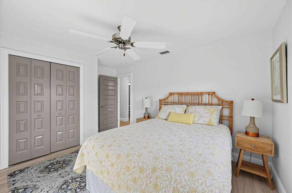 Bright and comfortable bedroom with a cozy bed and ceiling fan.