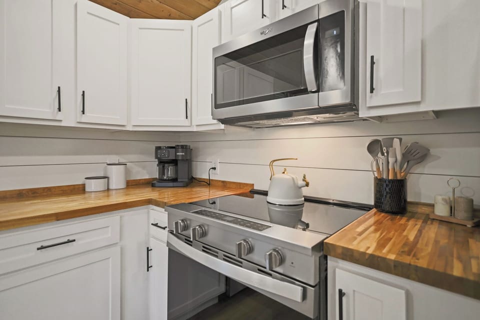 Bright modern kitchen with butcher-block counters & stainless appliances