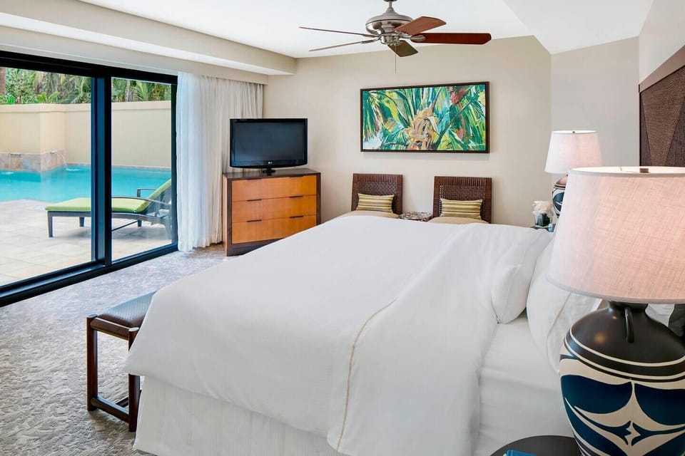 Spacious bedroom with pool access and serene indoor-outdoor style