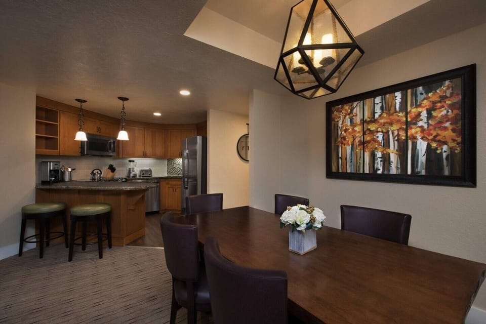 Spacious dining area with full kitchen, breakfast bar, and warm modern style