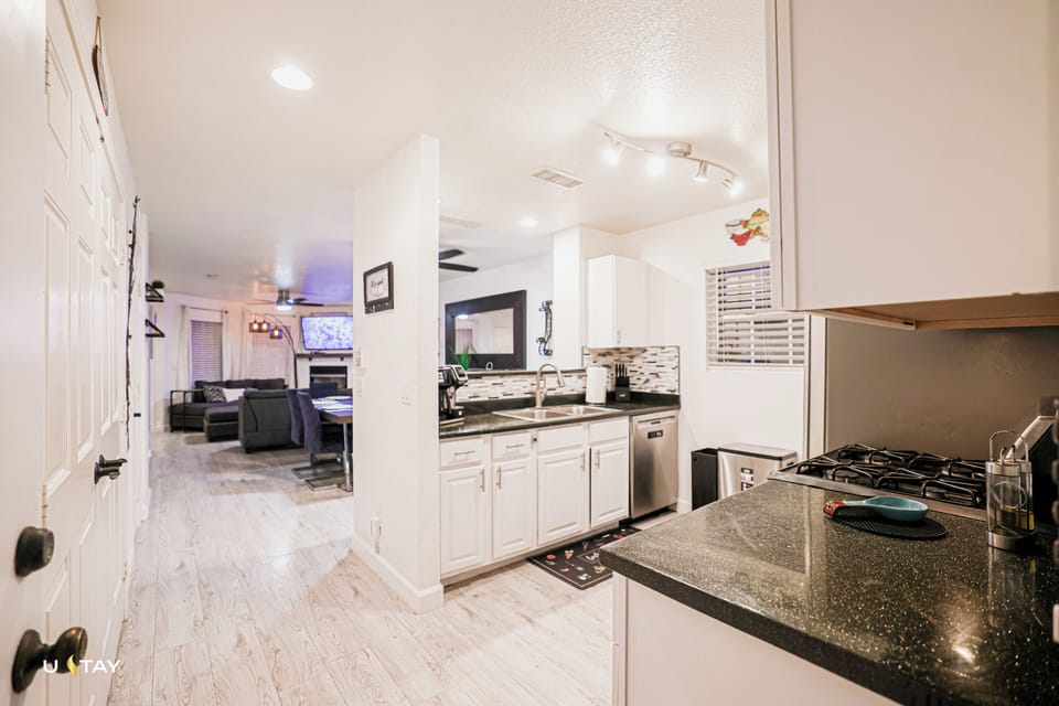 Bright granite kitchen with gas range, opening to a cozy TV lounge.