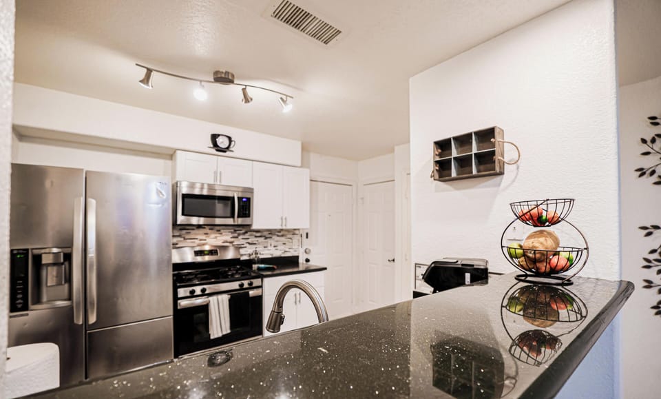 Modern kitchen with granite bar and stainless appliances—cook ready
