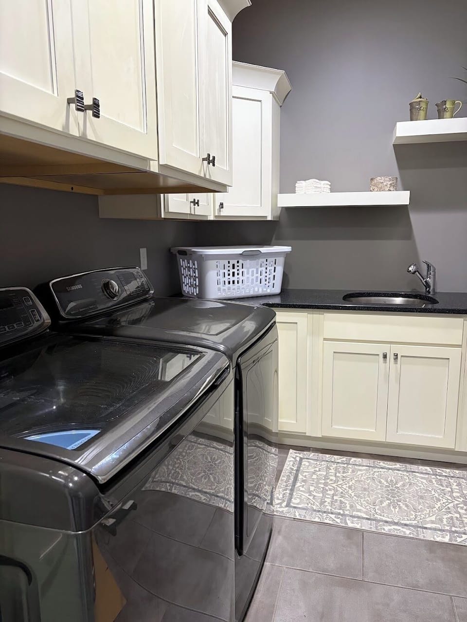 Spacious laundry room with washer/dryer, utility sink, and ample storage