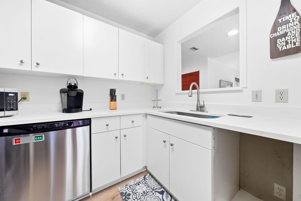 Kitchen with Sink, Keurig and Pass-Through - The kitchen has a double sink, dishwasher, Keurig, and pass-through toward the dining area.