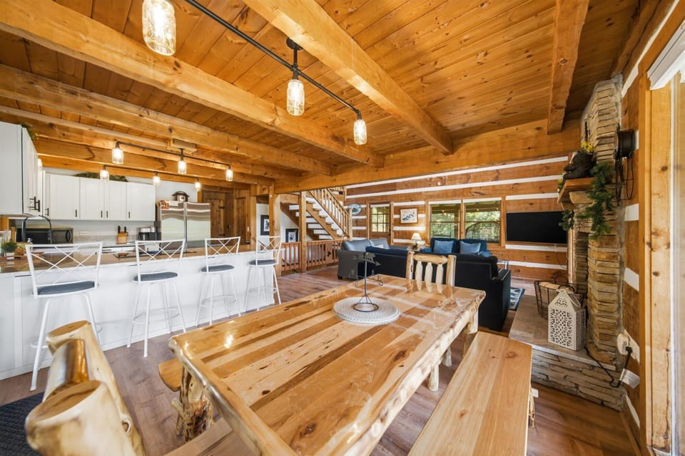 Gather around the handcrafted wooden table in this airy, sunlit cabin, where soaring timber beams and wide-open views create a peaceful retreat for meals, conversations, and unforgettable moments with loved ones.