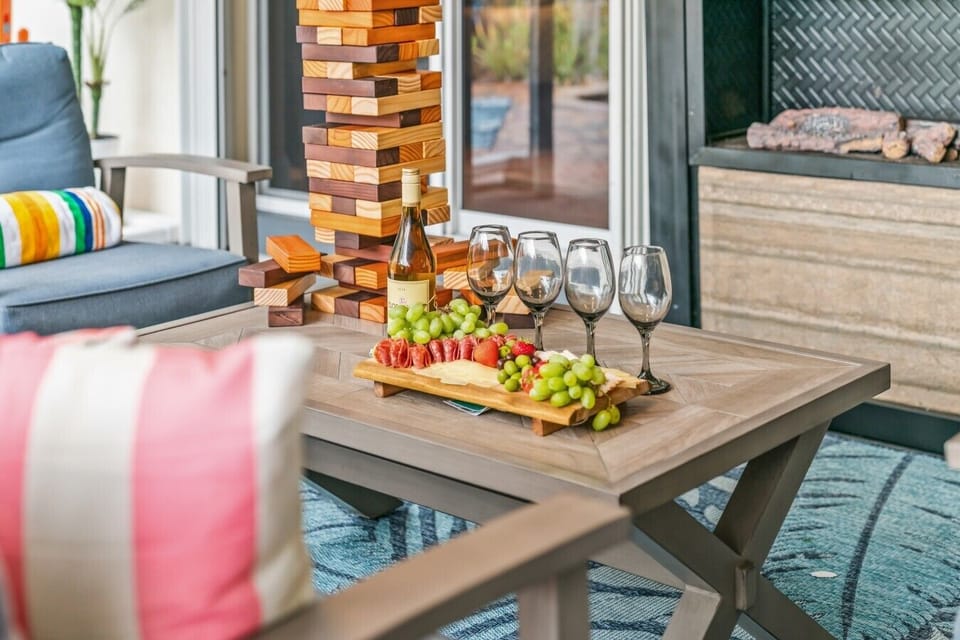 Covered Patio Entertainment Lounge: Host evening cocktails and charcuterie spreads in style under the covered lanai, complete with deeply cushioned patio seating, an outdoor coffee table, a giant wooden Jenga game, and a cozy outdoor fireplace.