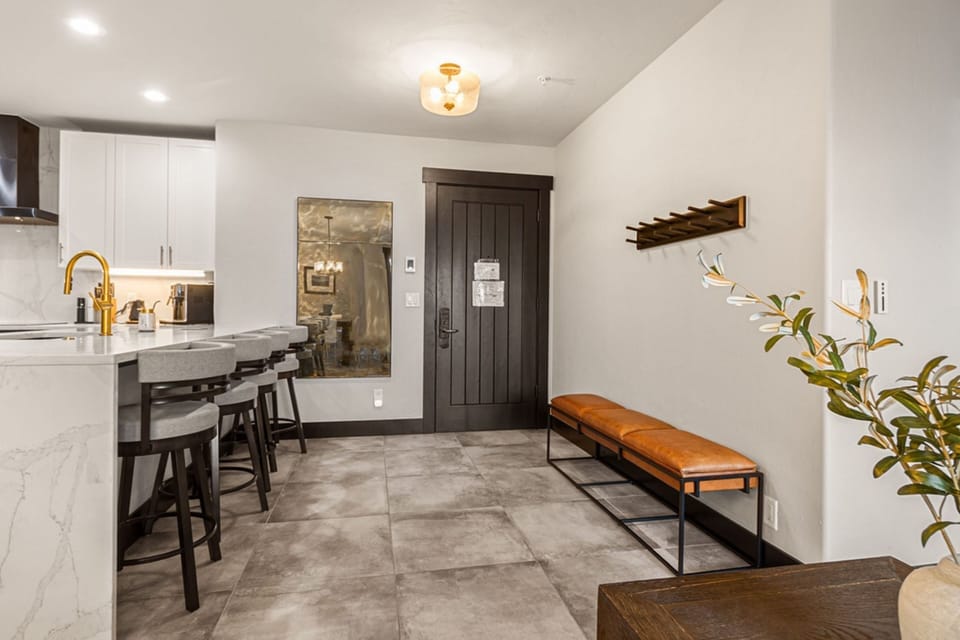 Step into your modern retreat where warm gold accents complement sleek white surfaces and natural textures, creating a welcoming space to unwind after a day of adventure.