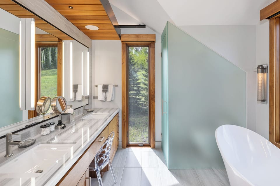 Unwind in your spa-like retreat, where natural light and serene forest views create the perfect sanctuary for your morning routine or evening soak.