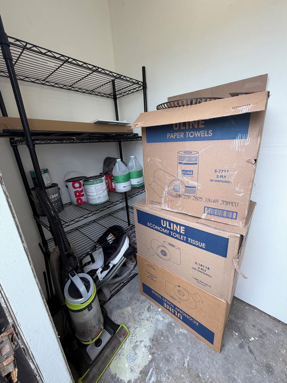 Well-stocked utility closet with cleaning gear and extra guest essentials