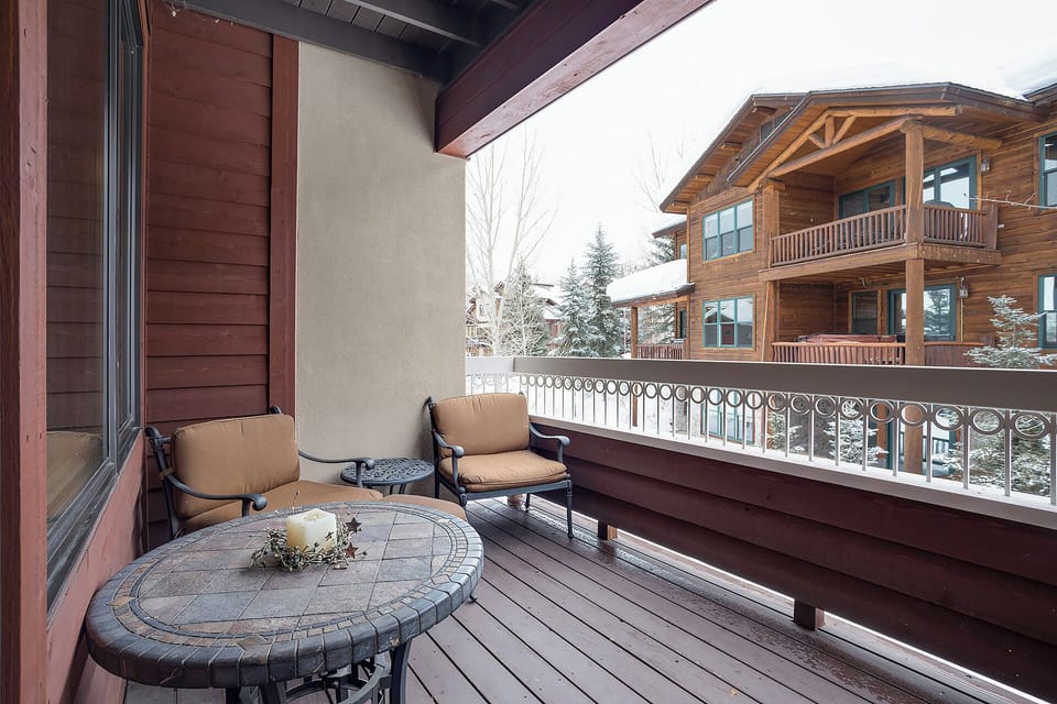 Relax on your private balcony with cozy seating, taking in peaceful winter views of neighboring alpine chalets and snow-dusted evergreens. A perfect spot to unwind with morning coffee.