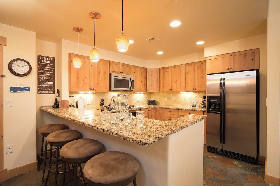 Your fully equipped kitchen features granite countertops, stainless steel appliances, and a breakfast bar where you can gather for morning coffee or meal prep together.