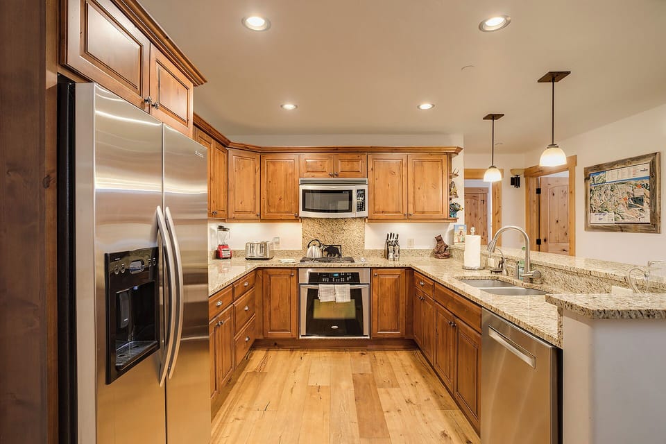 Step into your fully equipped kitchen with gleaming granite countertops, stainless appliances, and warm wood cabinetry—everything you need to whip up a delicious meal after a day exploring.
