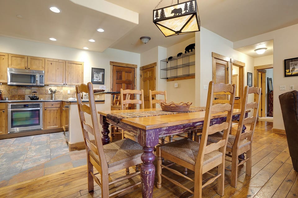 Gather around this rustic dining table, where charming lodge-inspired décor meets a fully equipped kitchen—perfect for creating memorable meals together during your mountain getaway.