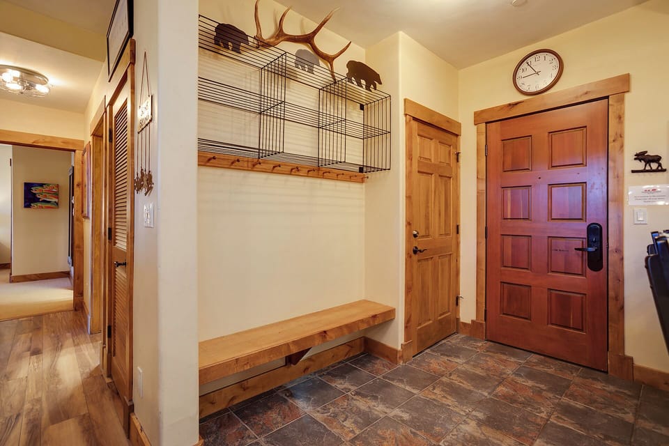 Step into this welcoming entryway with rustic charm—wood bench for your gear, mountain-inspired décor above, and warm touches that make you feel right at home from the moment you arrive.