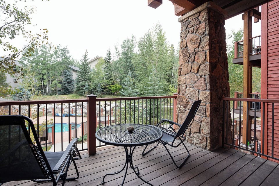 Your private balcony overlooks a sparkling pool, framed by evergreen trees and mountain air. Settle into the chairs, sip your morning coffee, and soak in the peaceful resort views.