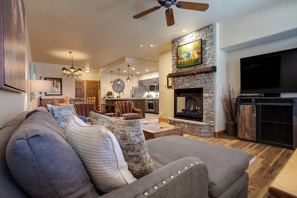 Sink into plush seating by the glowing stone fireplace, or gather around the open kitchen—your cozy mountain retreat awaits with warm wood finishes and thoughtful touches throughout.