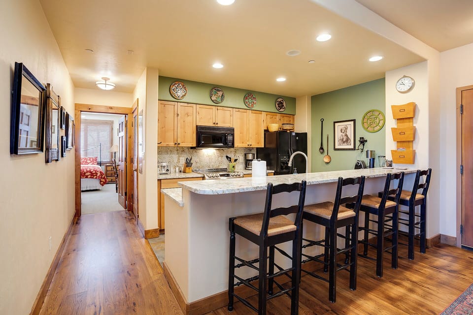 Your kitchen invites you to gather at the breakfast bar, where you'll enjoy morning coffee surrounded by warm wood tones, granite countertops, and thoughtful decor that makes this space feel like home.