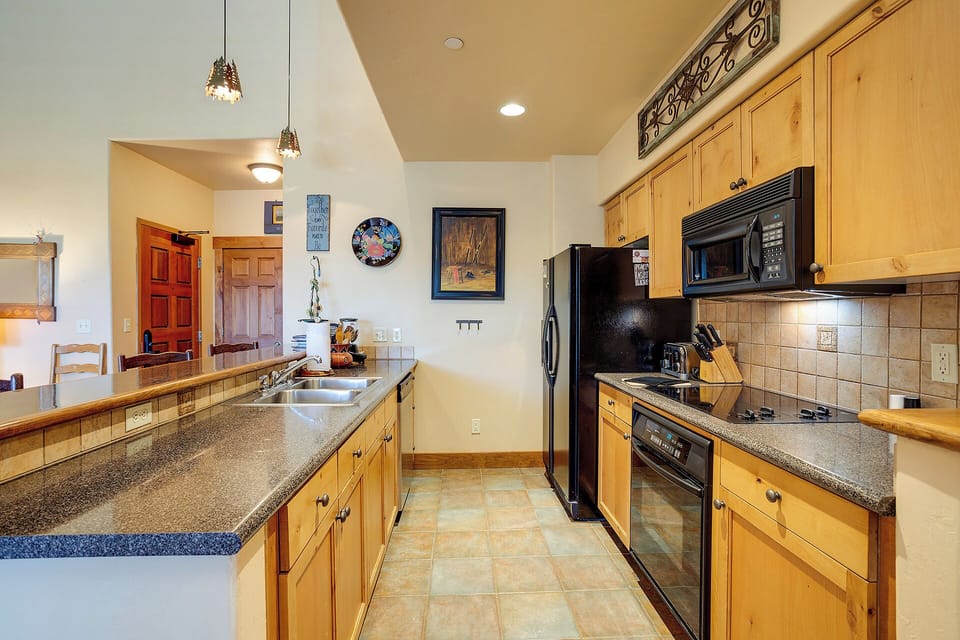 Your spacious, fully-equipped kitchen features granite counters, modern appliances, and warm wood cabinetry—perfect for preparing meals or gathering with friends over morning coffee.