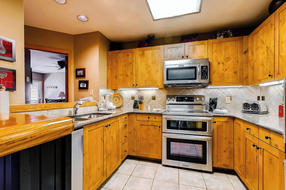 You'll love preparing meals in this fully equipped kitchen with warm wood cabinetry, stainless appliances, granite countertops, and a cheerful skylight bathing the space in natural light.