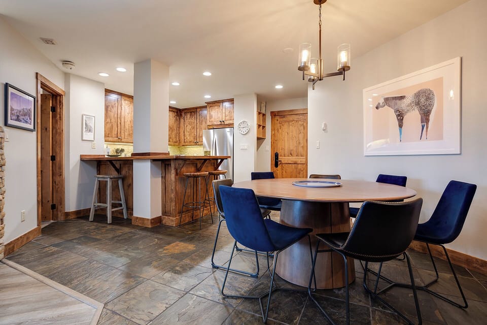 Gather around the elegant dining table for memorable meals, with a stylish kitchen just steps away featuring warm wood cabinetry and modern stainless appliances ready for your culinary adventures.