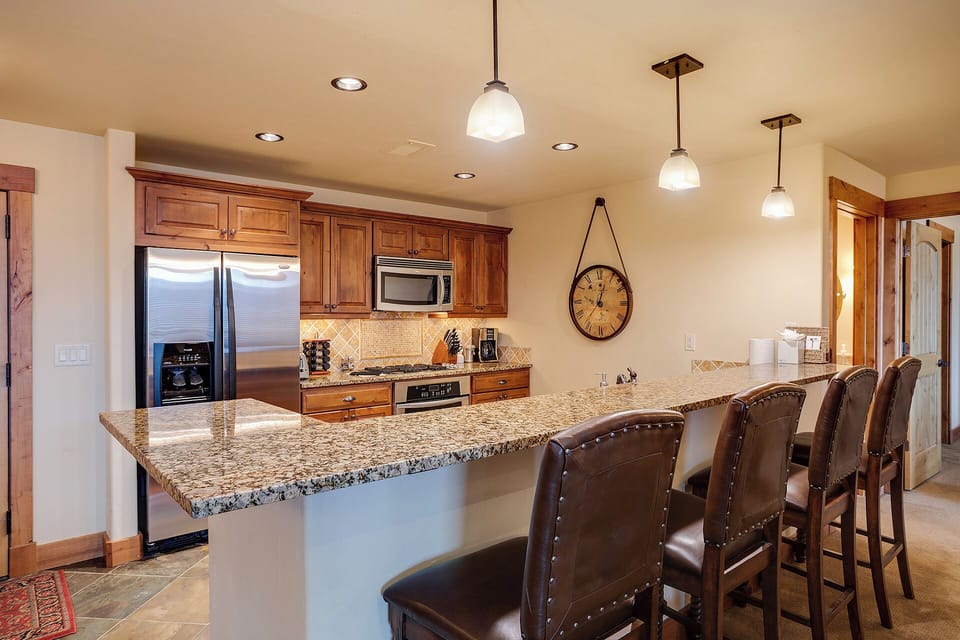Gather around the spacious granite island where morning coffee and evening conversations flow easily. Warm wood cabinetry and modern appliances make your mountain retreat feel like a second home.