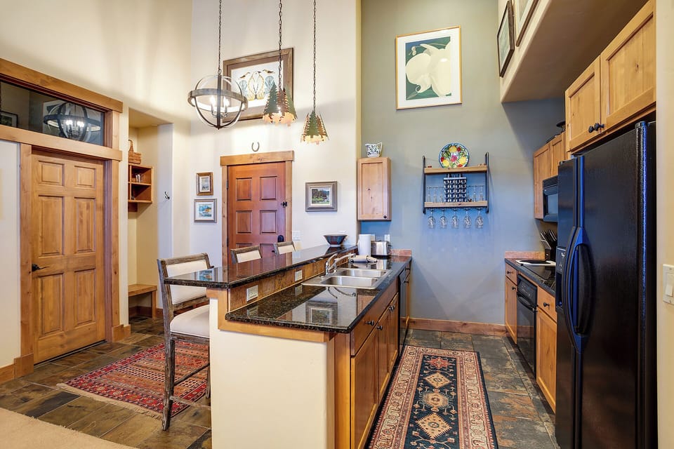 Gather around the kitchen island for meals and memories in this open, well-equipped space with modern appliances, warm wood cabinetry, and a cozy dining nook that makes cooking feel like part of your vacation.