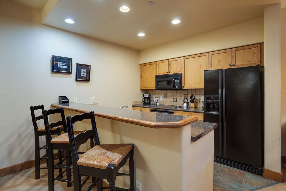 Your fully equipped kitchen features modern appliances, granite countertops, and a convenient breakfast bar—perfect for preparing home-cooked meals or enjoying morning coffee together.