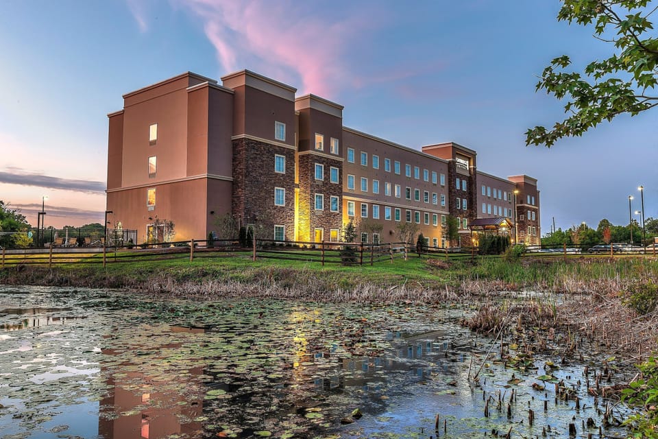 Building reflected in the pond at sunset — the park-like grounds set this apart from a typical hotel stay