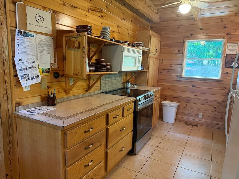 Wood cabinetry, tiled counters, and a fully equipped cooking area.