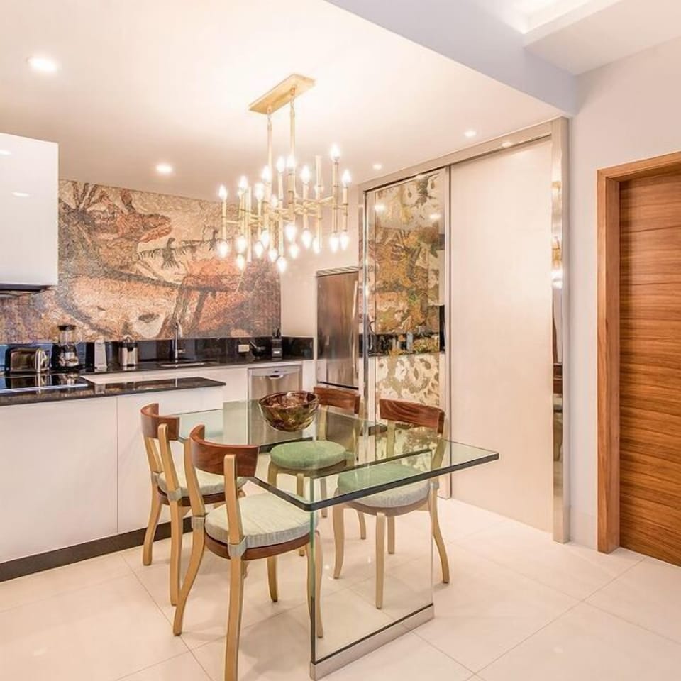 Elegant dining area with designer lighting and a sleek modern kitchen