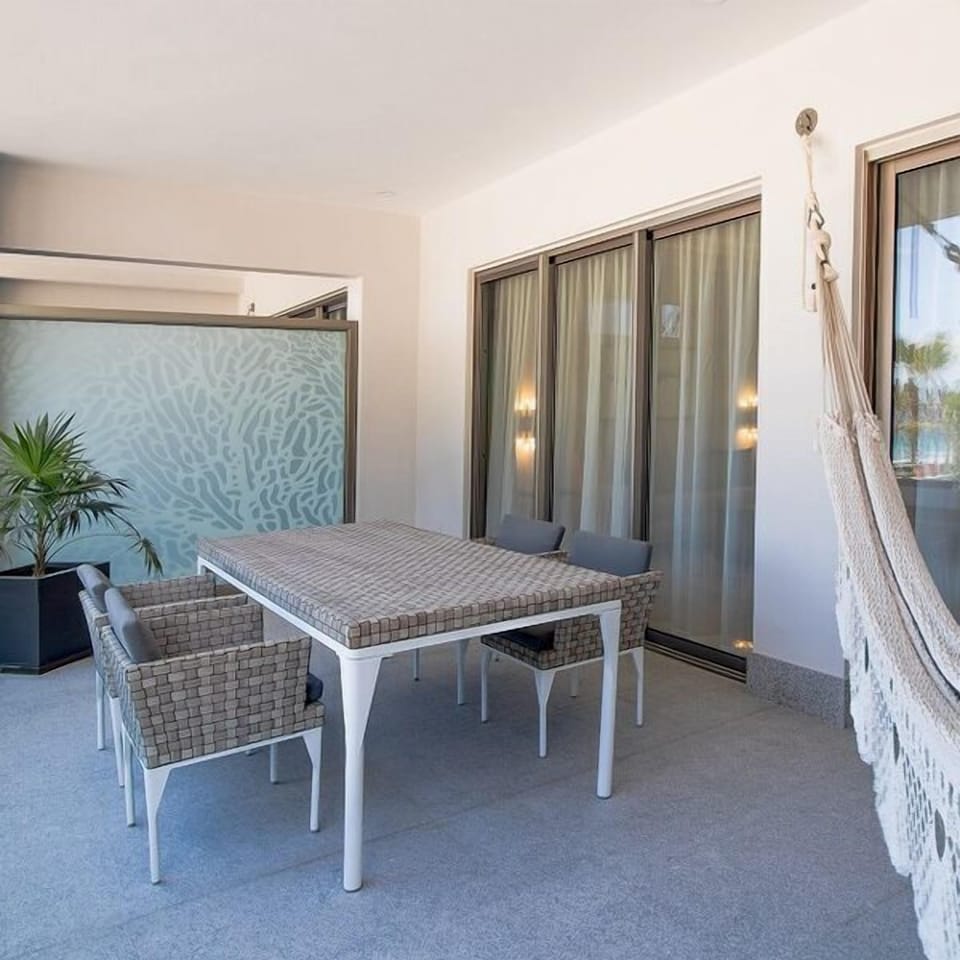 Covered patio with outdoor dining, hammock, and private resort-style feel