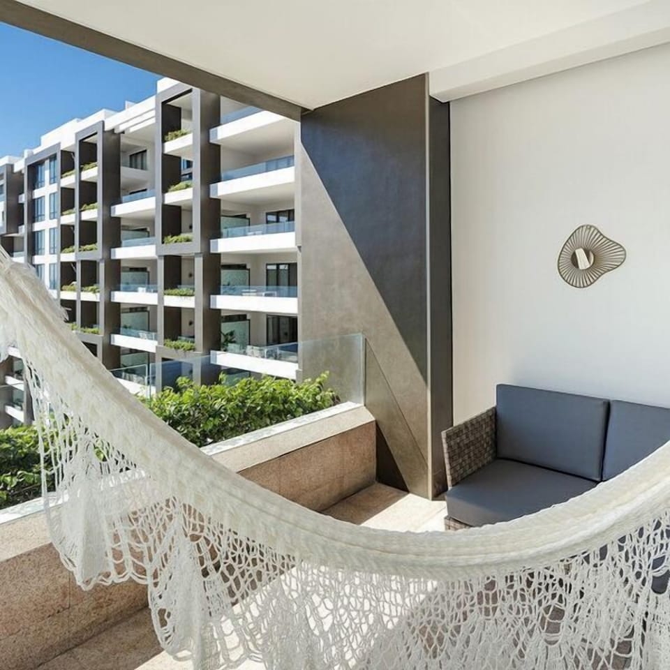 Sunny private balcony with hammock lounge and modern resort-style views