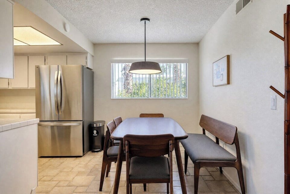 Gather around this cozy dining space where sunlight streams through the window, perfect for sharing meals and making memories together during your stay.