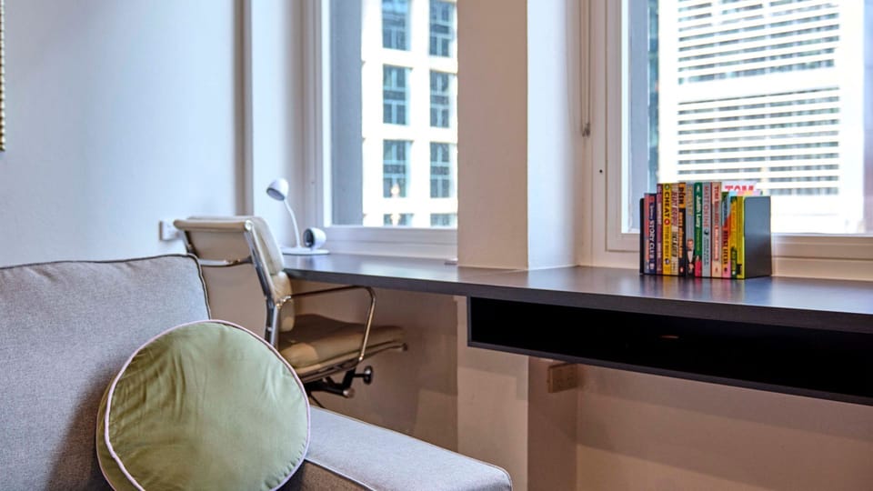 Dedicated desk setup with a chair positioned by the window.