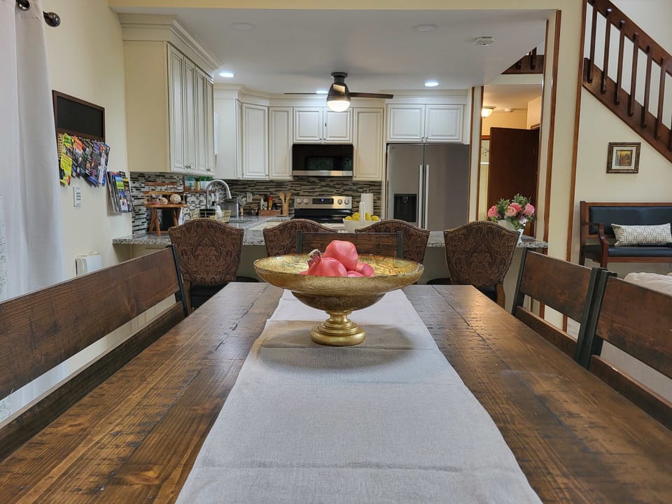 A soaring two-story living space with a loft overlook, staircase, and open sightlines straight into the kitchen.
