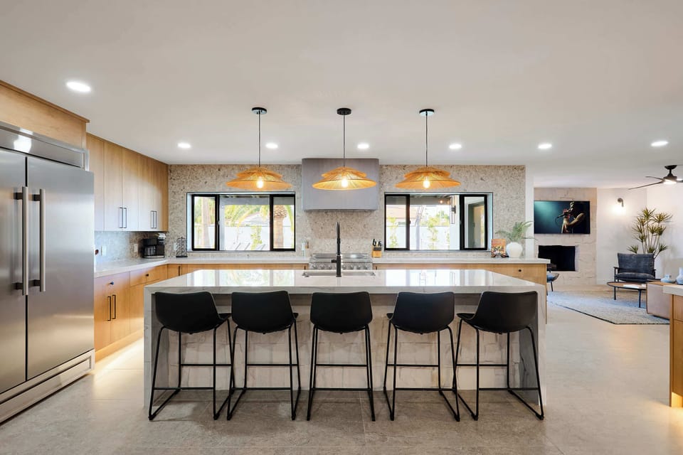 Sleek open concept kitchen with stainless steel appliances,  large island with breakfast bar seating for 5, coffee bar with espresso machine,  and fully equipped with your basic cooking essentials. 