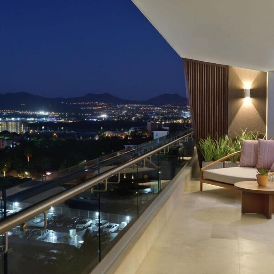 Modern private balcony with city lights and mountain views at night