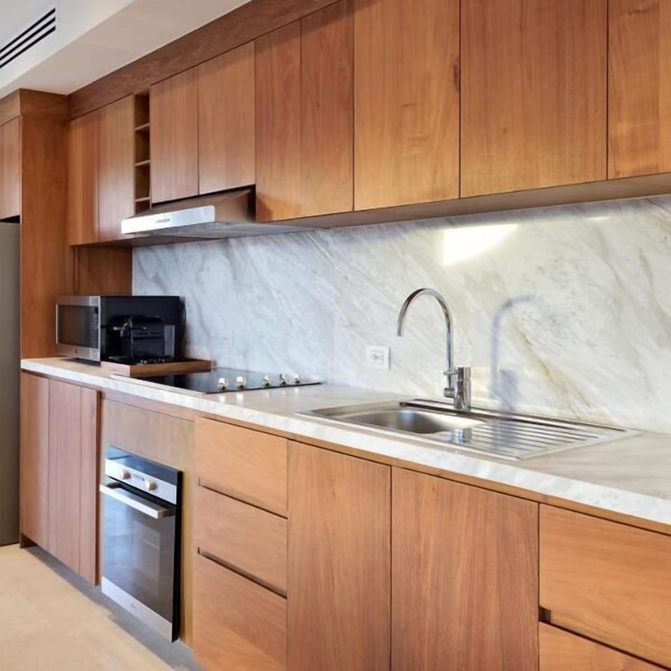 Modern wood kitchen with marble finishes and full cooking essentials