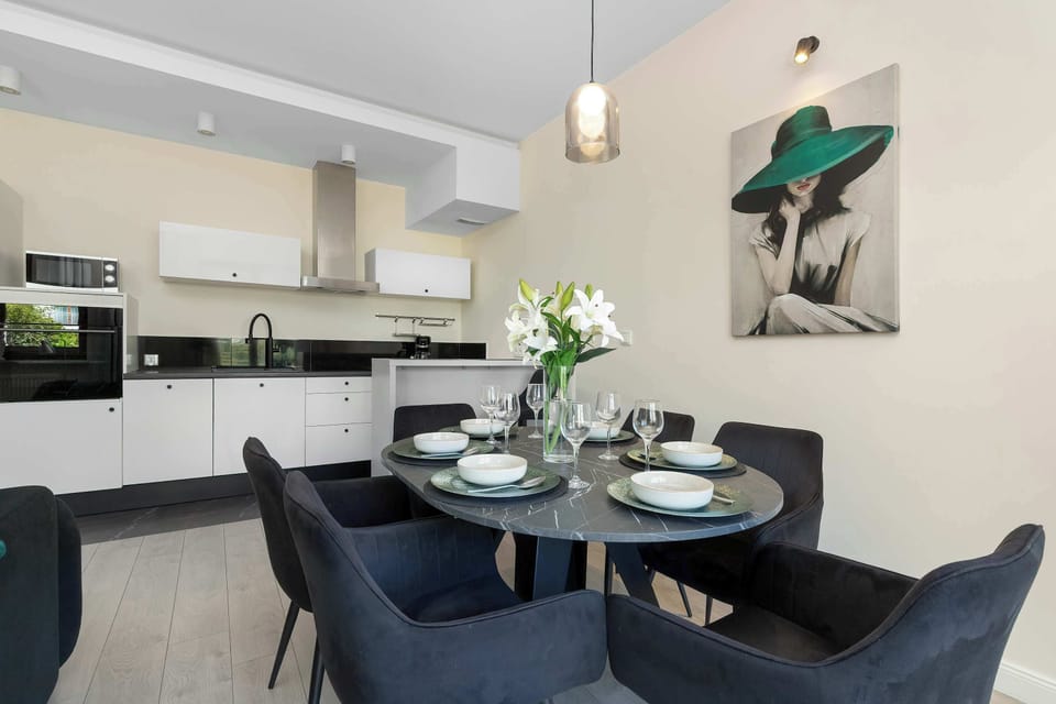 A stylish dining area with a round table and comfortable chairs connected to the kitchen. The space is bright and perfect for enjoying meals together.