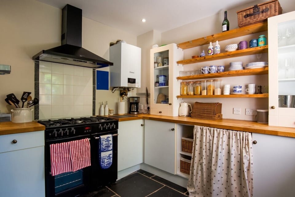 Country kitchen with range cooker and open shelving for home cooking