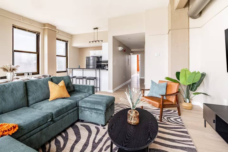 Open-concept living room, dining area, and fully equipped kitchen with abundant natural light, ideal for relaxing, dining, and extended stays.