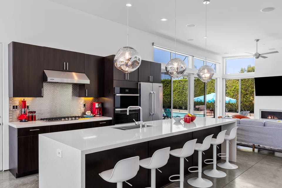 Stainless steel appliances, counter seating for 6 guests, cooking essentials, and large island.