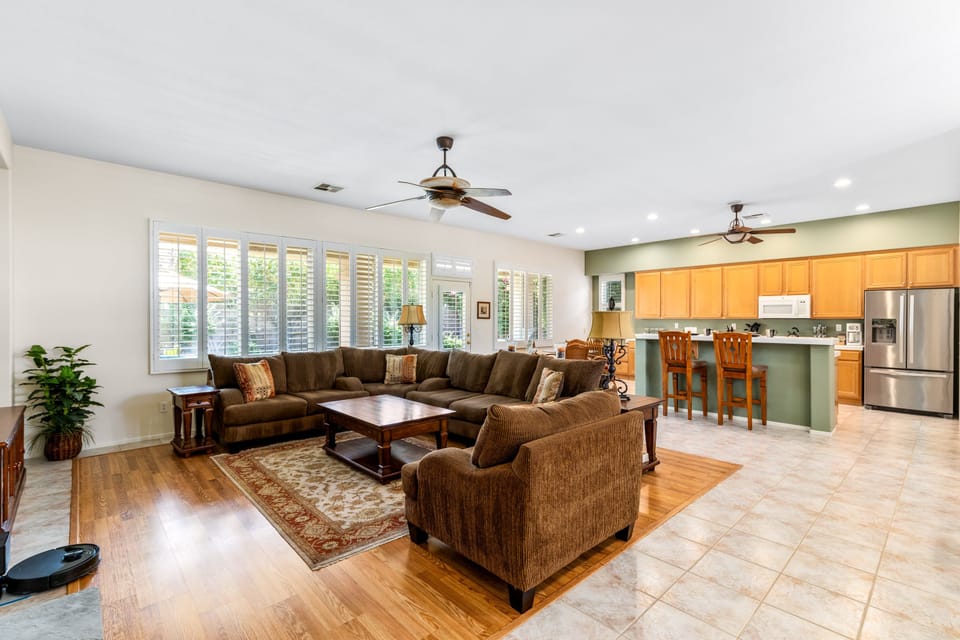 Ample seating, fireplace, flatscreen TV, and open-concept living space.