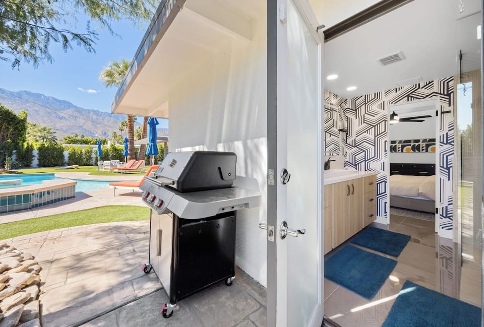 Step into your modern kitchen featuring geometric tile accents and sleek amenities, with BBQ facilities just outside for perfect poolside grilling.