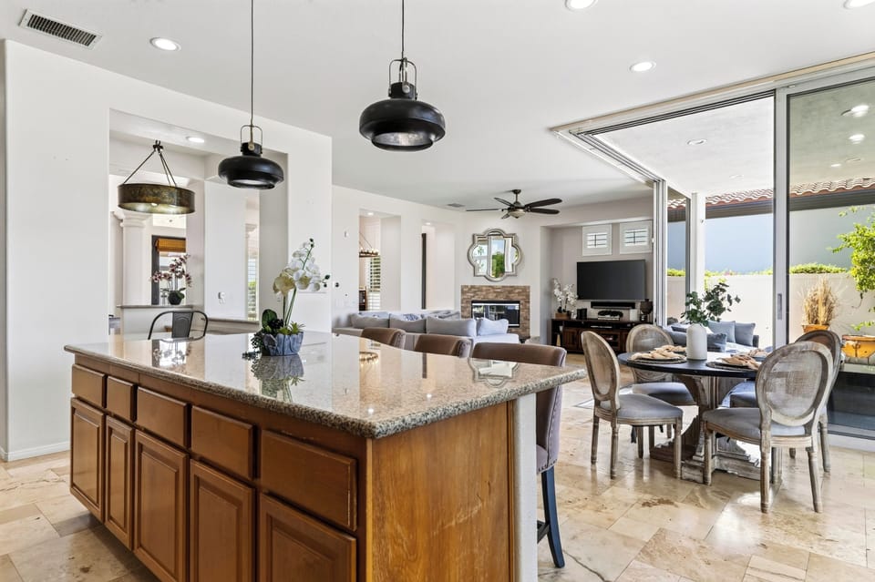 Large kitchen island anchors the open layout beside dining and living spaces.